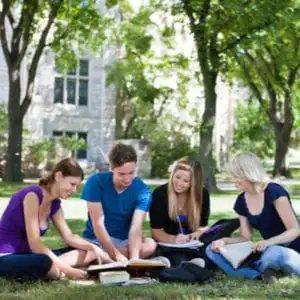 college students studying on the lawn on campus
