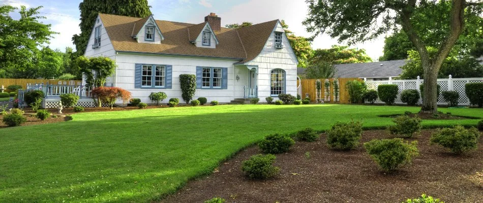 White house in Perkasie, PA, with dense green lawn.